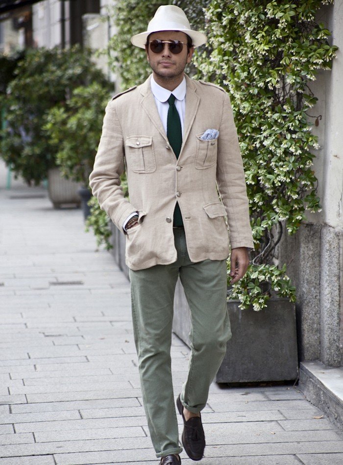 Que dire? Cette saharienne est tellement courte qu’elle confère une allure simiesque à son porteur, les épaulettes militaires jurent avec le col club de la chemise. Le chapeau et la pochette surchargent inutilement l’ensemble (déjà bien chargé par quatre poches plaquées). Le rappel autour de la couleur verte permet d’achever cet ignoble tableau.