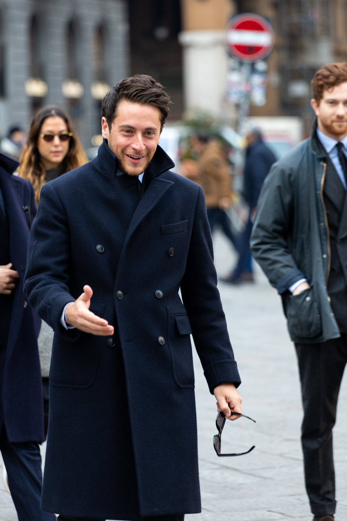 Enfin un très beau manteau ! Regardez comment les boutons sont rapprochés sur un plan vertical et concentrés sur la partie supérieure à la taille. Cela permet de dégager une bonne longueur pour le bas du manteau et d’allonger la silhouette. Le boutonnage croisé est permis car il permet de rajouter du coffre et donner de l’épaisseur à une silhouette déjà bien élancée par le manteau. Par ailleurs, l’épaule est bonne et les revers équilibrés (ni trop larges façon proxénète ni trop étriqués façon animateur sur FR2). Notez également les poches boites aux lettres. Demandez ce genre de détail à votre atelier de demi-mesure plutôt que des crans ratés ou des revers XXL.
