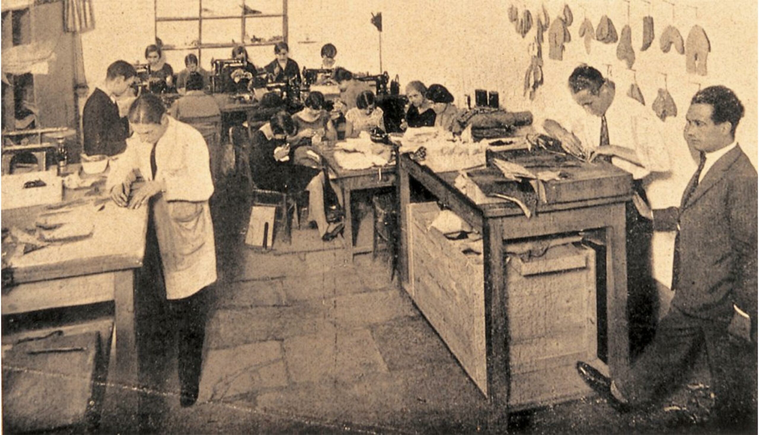 L’atelier Ferragamo à Florence en 1935, au premier plan les coupeurs qui lèvent (coupent) les différentes parties du cuir nécessaires à la fabrication de la chaussure. Au second plan les piqueuses qui  se chargent de coudre les différents morceaux de cuir. Sur le mur de droite vous pouvez voir certains des éléments en cuir qui composent une chaussure. (Source: l’Art de la chaussure)
