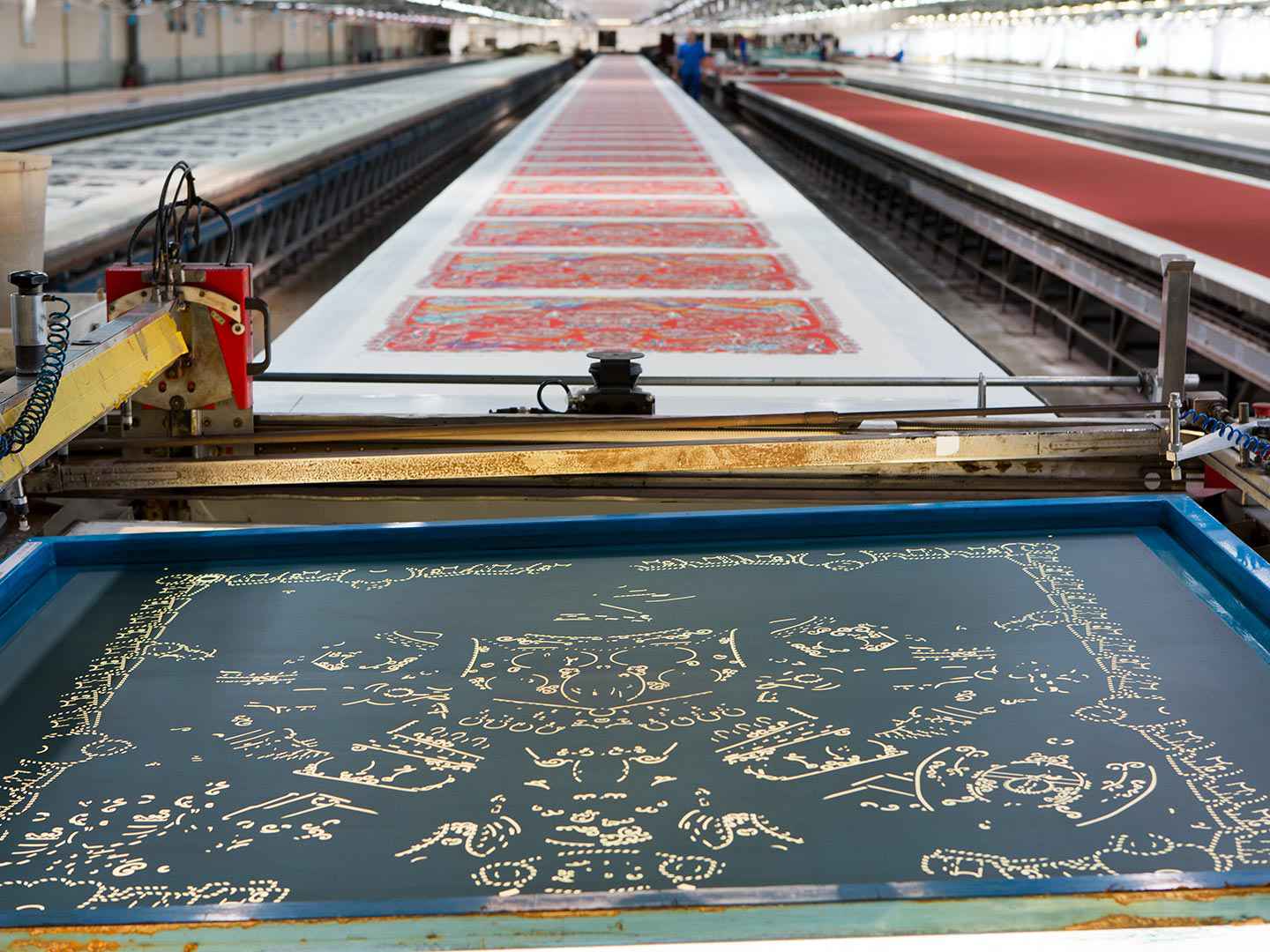 Les tables d’impression chez Hermès, avec au premier plan un cadre. Cette photo illustre bien la place considérable dont il est nécessaire de disposer pour faire de l’impression par cadre plat à un niveau industriel. (Source : Hermès)